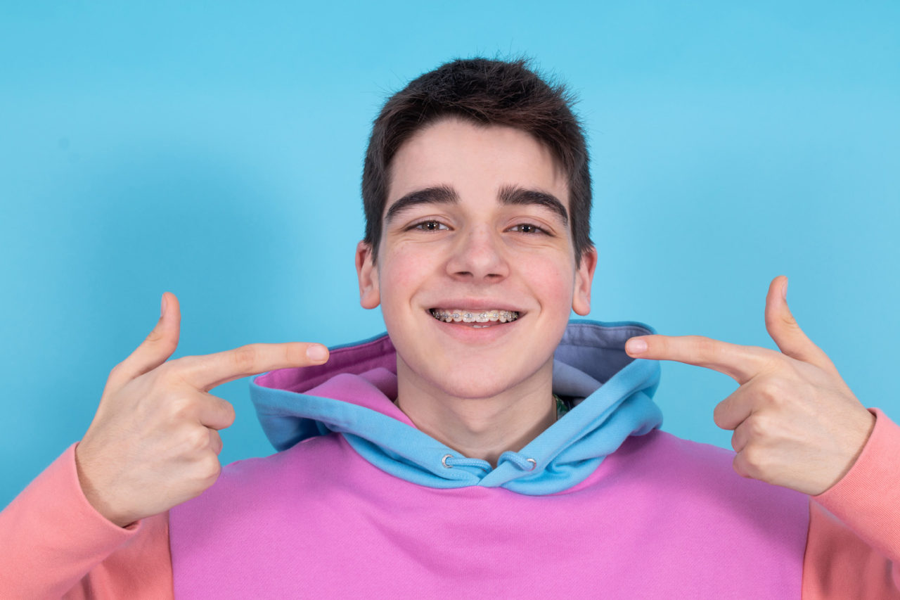 portrait of young teenage girl isolated showing braces and orthodontics