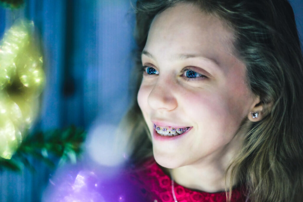 Teen girl smiling with braces showing straightening teeth during orthodontic treatment