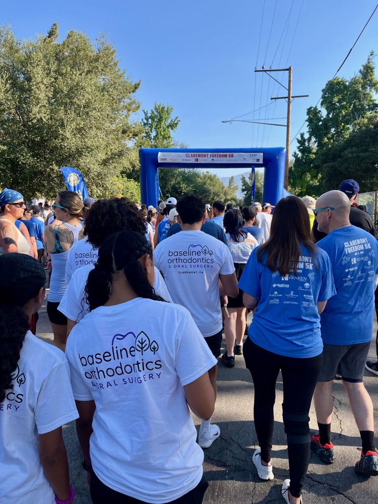 Baseline Orthodontics team participating in a community event in Claremont with people walking near race start line
