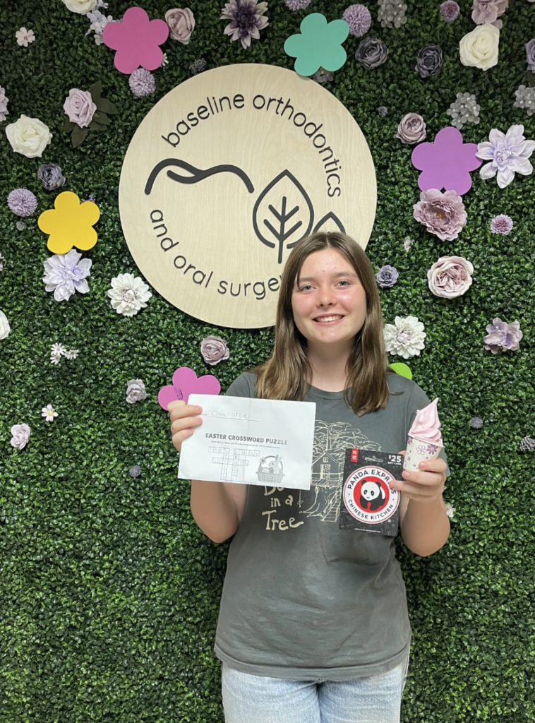 Smiling orthodontic patient holding contest prize and ice cream at Baseline Orthodontics office in Claremont