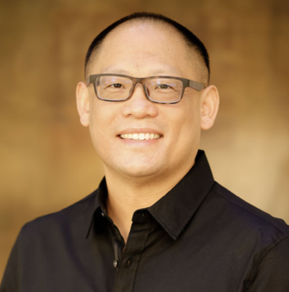 Professional headshot of a smiling orthodontist wearing glasses at Baseline Orthodontics